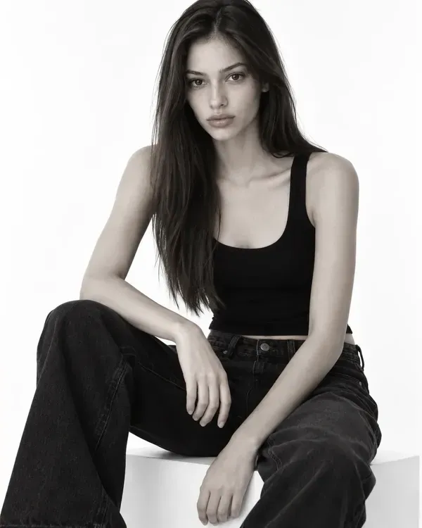 Three black and white photos of a model: a full-length shot, a headshot and a seated pose, the mix of photos a comp card needs
